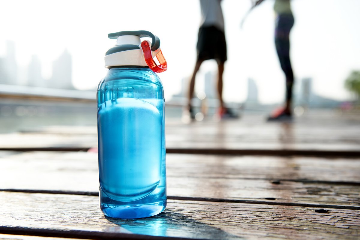 water bottle with 2 people talking in background